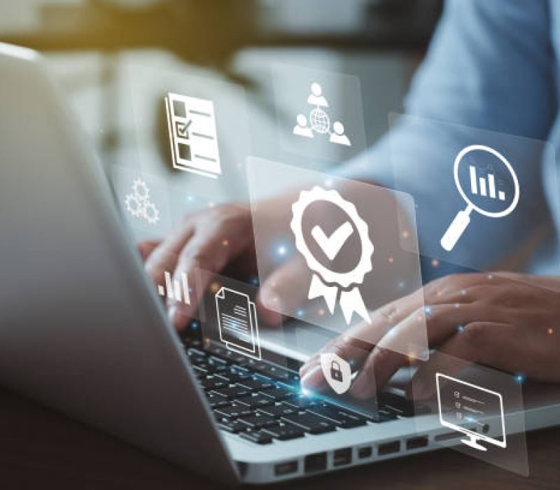 Businessman working on laptops with signs of the top service Quality control certification checked guarantees of the standard of company product. Concept on virtual screen."n"n"n